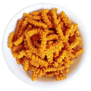A plate of golden-brown tomato murukku, a crispy savory snack.